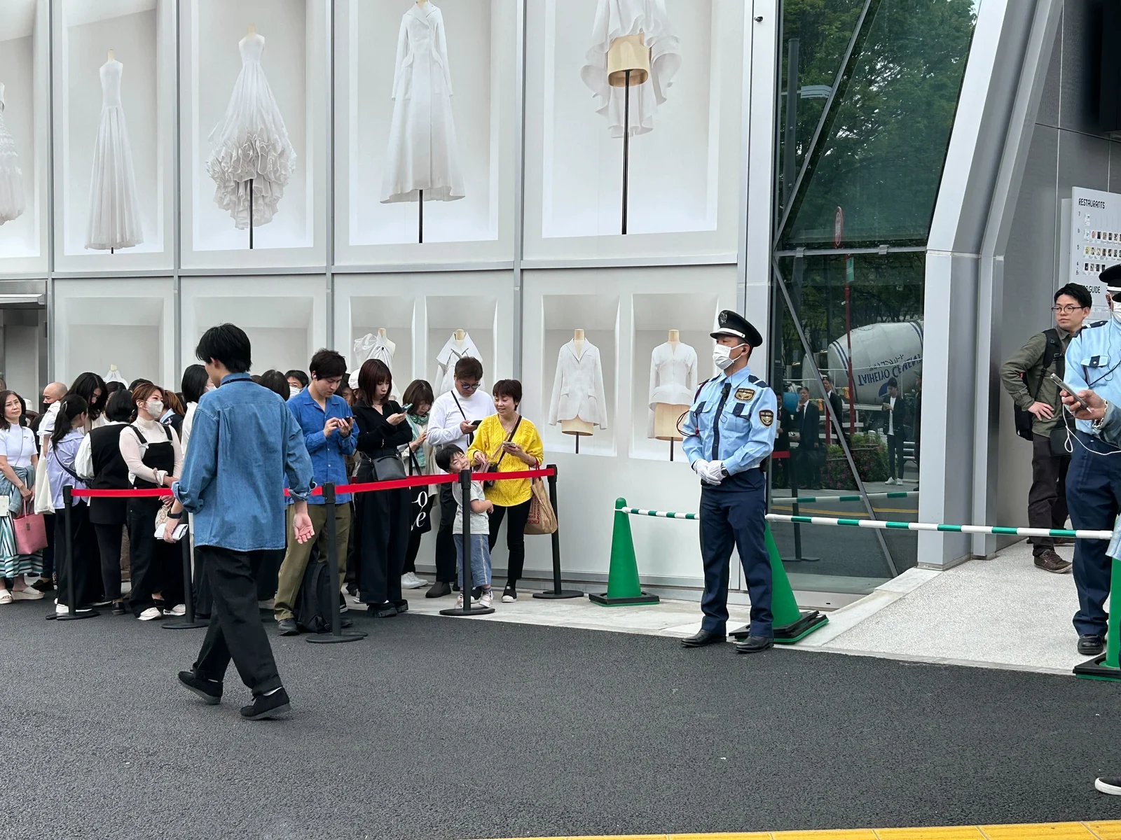 来場者が並ぶ施設入口で警備にあたる警備士